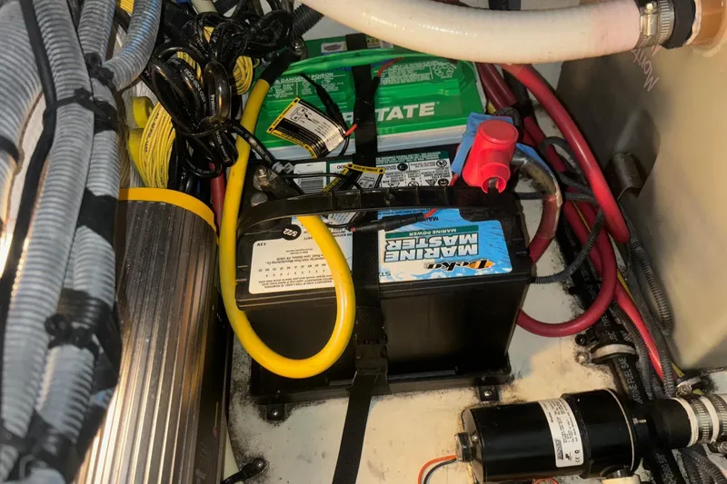Slide: The Image of Battery compartment of a 2008 Monterey 250 Cruiser with wiring and marine equipment. - 19
