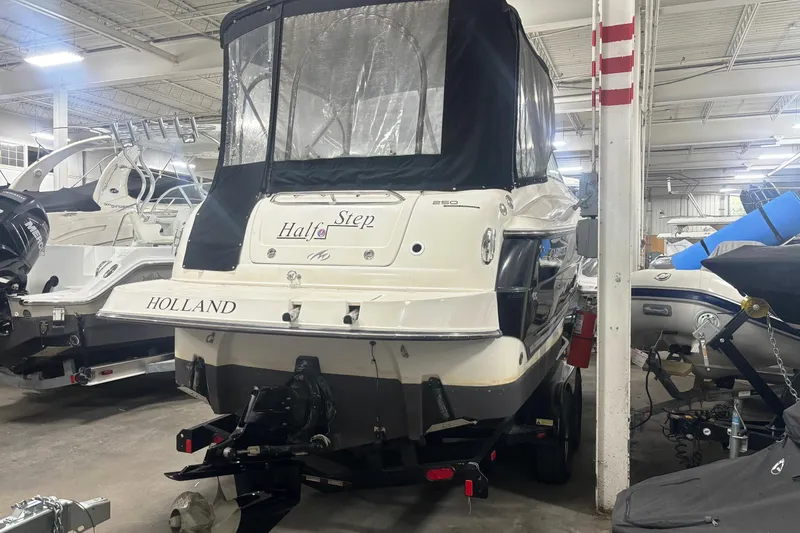 Slide: The Image of 2008 Monterey 250 Cruiser boat in storage, featuring a covered stern and trailer. - 3