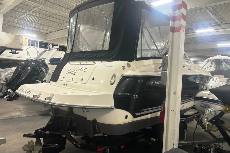 Slide: The Image of 2008 Monterey 250 Cruiser boat in indoor storage, featuring black and white exterior. - 4
