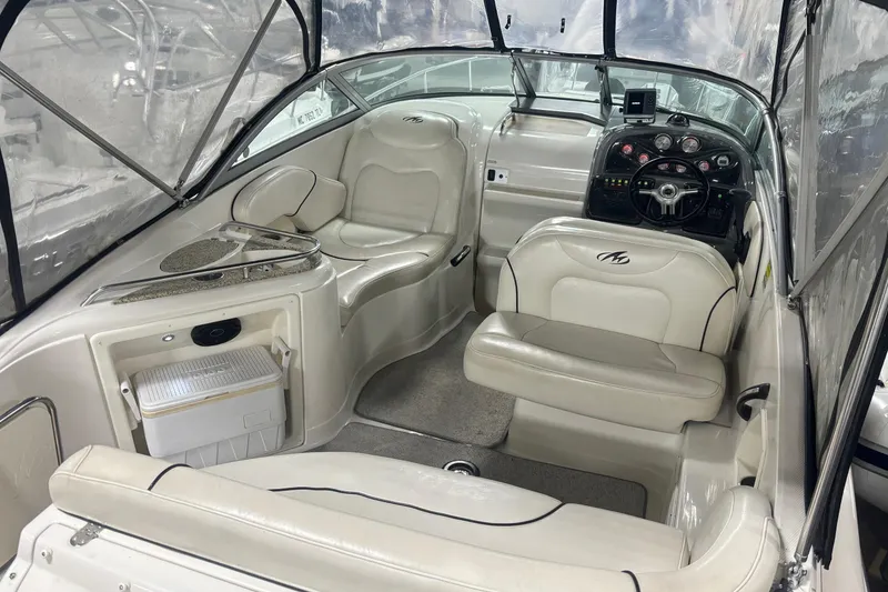 Slide: The Image of Interior of a 2008 Monterey 250 Cruiser boat with white seating and dashboard. - 7
