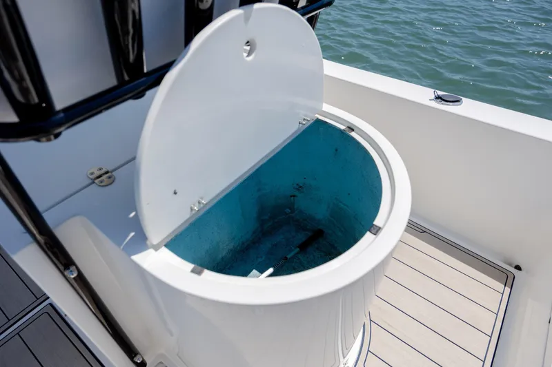 Slide: The Image of Open storage compartment on a 2022 Banks Panga 26 boat, with ocean in the background. - 12