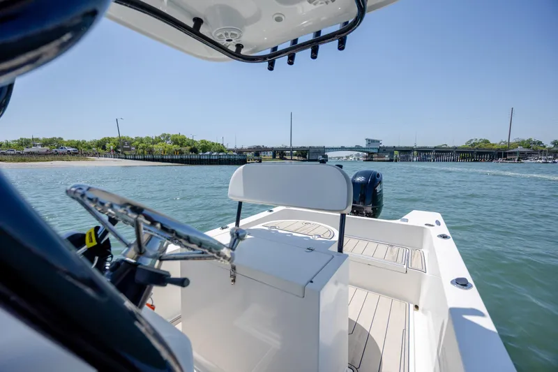 Slide: The Image of 2022 Banks Panga 26 boat on water near a bridge under clear blue sky. - 14