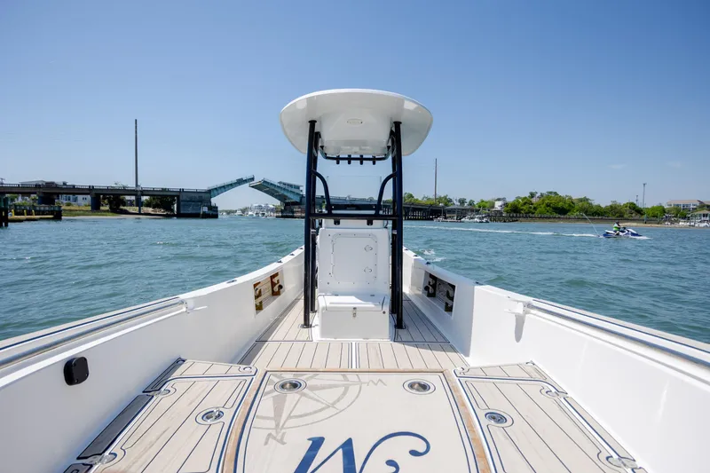 Slide: The Image of 2022 Banks Panga 26 boat on water near open drawbridge, clear sky background. - 18