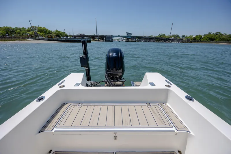 Slide: The Image of 2022 Banks Panga 26 boat on water, showcasing rear deck and outboard motor. - 9
