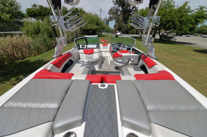 Slide: The Image of 2014 MasterCraft X-25 boat interior with red and gray seating, parked on grass. - 12