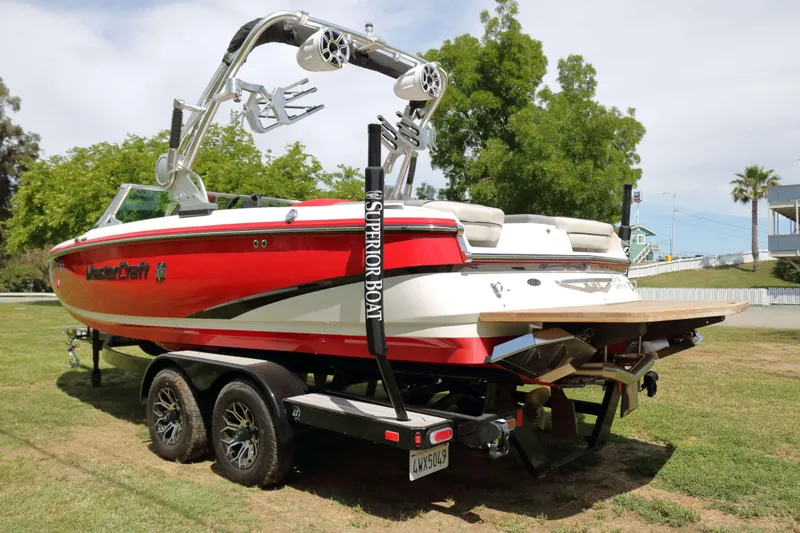 Slide: The Image of 2014 MasterCraft X-25 boat on trailer, red and white design, parked on grass. - 5