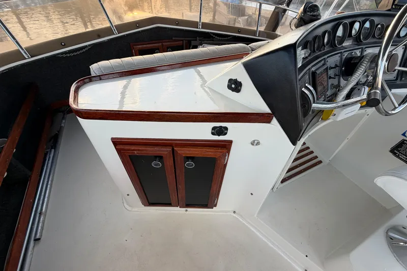 Slide: The Image of 1984 Carver 3607 Aft Cabin Motor Yacht helm with wood accents and control panel. - 11