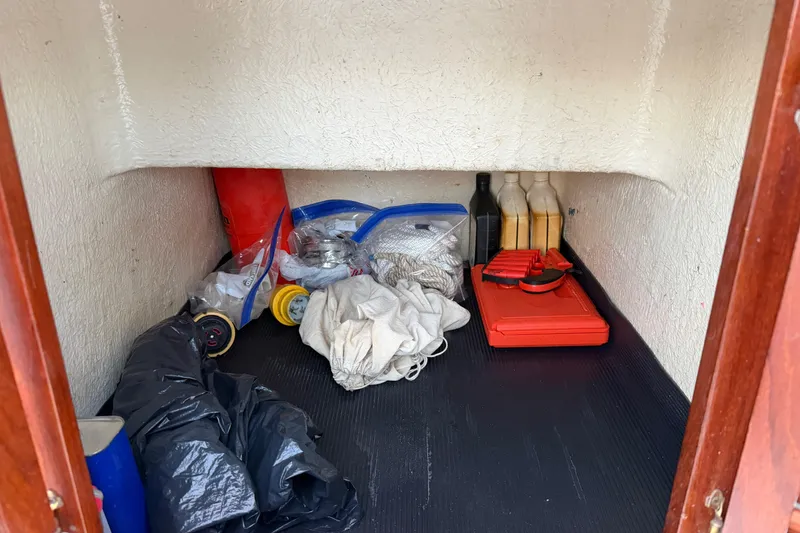 Slide: The Image of Storage compartment in 1984 Carver 3607 Aft Cabin Motor Yacht with various supplies. - 13