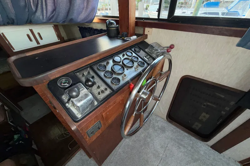 Slide: The Image of 1984 Carver 3607 Aft Cabin Motor Yacht helm with gauges and steering wheel. - 16