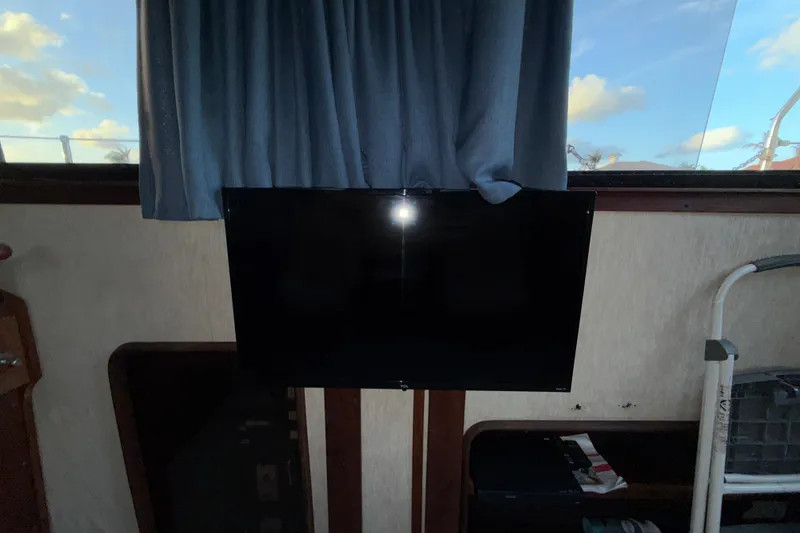 Slide: The Image of Flat-screen TV mounted inside 1984 Carver 3607 Aft Cabin Motor Yacht, blue curtains in background. - 21