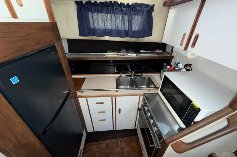 Slide: The Image of 1984 Carver 3607 Aft Cabin Motor Yacht kitchen with appliances and wooden cabinetry. - 23