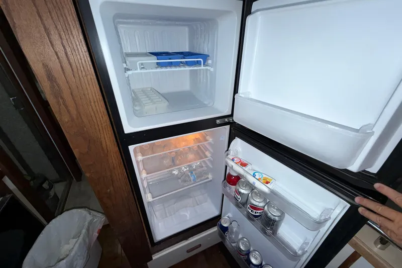 Slide: The Image of Open refrigerator on 1984 Carver 3607 Aft Cabin Motor Yacht, stocked with beverages and ice trays. - 25