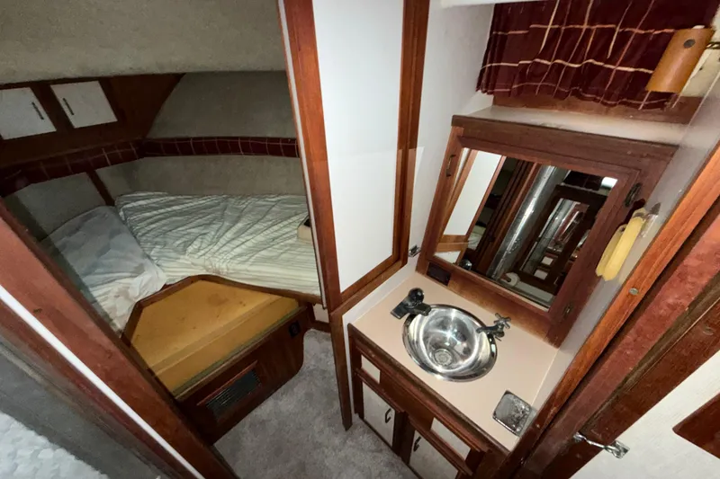 Slide: The Image of 1984 Carver 3607 Aft Cabin Motor Yacht interior with bed, sink, and mirror. - 28