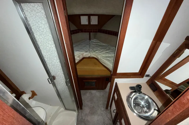 Slide: The Image of 1984 Carver 3607 Aft Cabin Motor Yacht interior with bed, sink, and shower. - 31