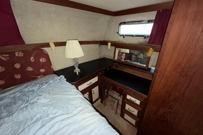 Slide: The Image of 1984 Carver 3607 Aft Cabin Motor Yacht interior with bed, lamp, and vanity area. - 33