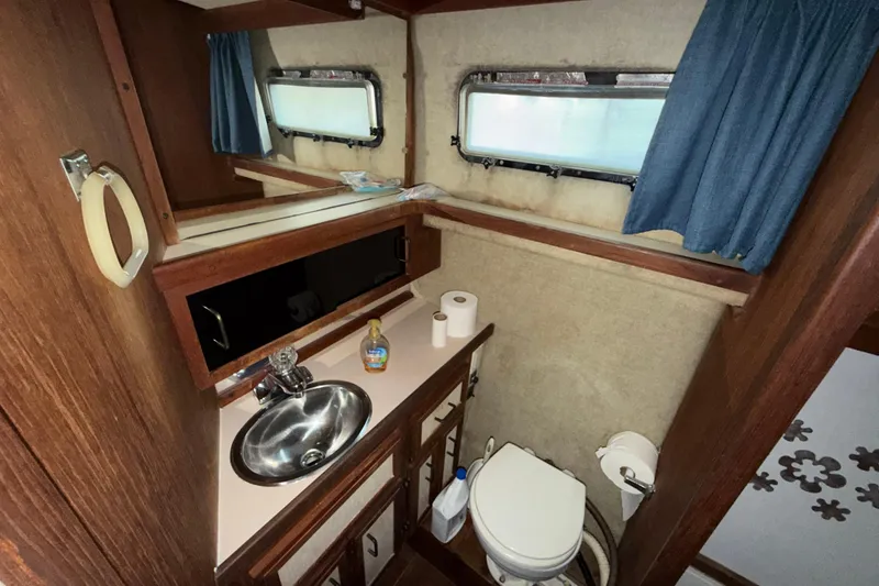 Slide: The Image of 1984 Carver 3607 Aft Cabin Motor Yacht bathroom with sink, toilet, and window. - 35