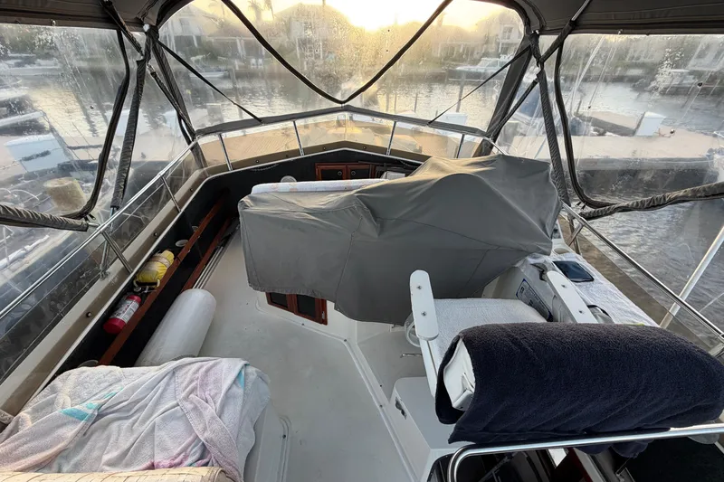 Slide: The Image of 1984 Carver 3607 Aft Cabin Motor Yacht interior with covered helm and marina view. - 6