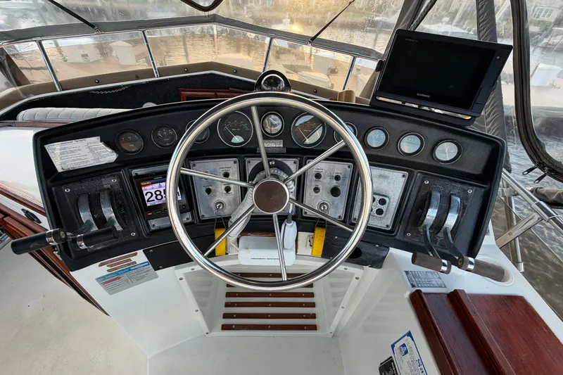 Slide: The Image of 1984 Carver 3607 Aft Cabin Motor Yacht helm with steering wheel and control panel. - 8