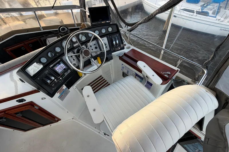 Slide: The Image of 1984 Carver 3607 Aft Cabin Motor Yacht helm with steering wheel and control panel. - 9