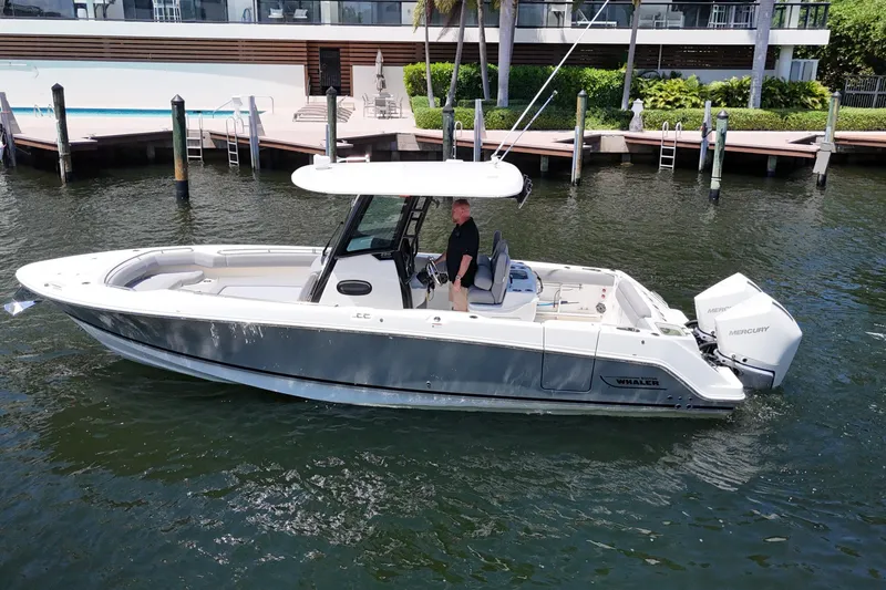 Slide: The Image of 2024 Boston Whaler 280 Outrage boat on water, dockside view. - 11