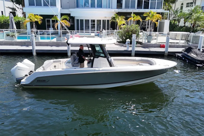 Slide: The Image of 2024 Boston Whaler 280 Outrage boat docked near waterfront property. - 13