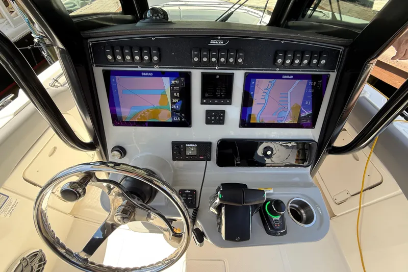 Slide: The Image of 2024 Boston Whaler 280 Outrage helm with dual Simrad displays and modern controls. - 16