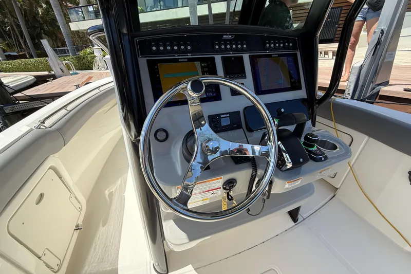 Slide: The Image of 2024 Boston Whaler 280 Outrage helm with advanced navigation controls and sleek steering wheel. - 17