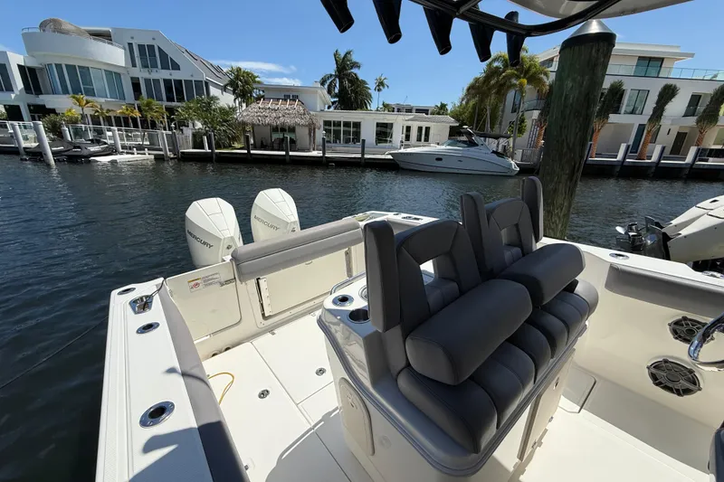 Slide: The Image of 2024 Boston Whaler 280 Outrage boat docked, featuring dual Mercury engines and luxurious seating. - 19