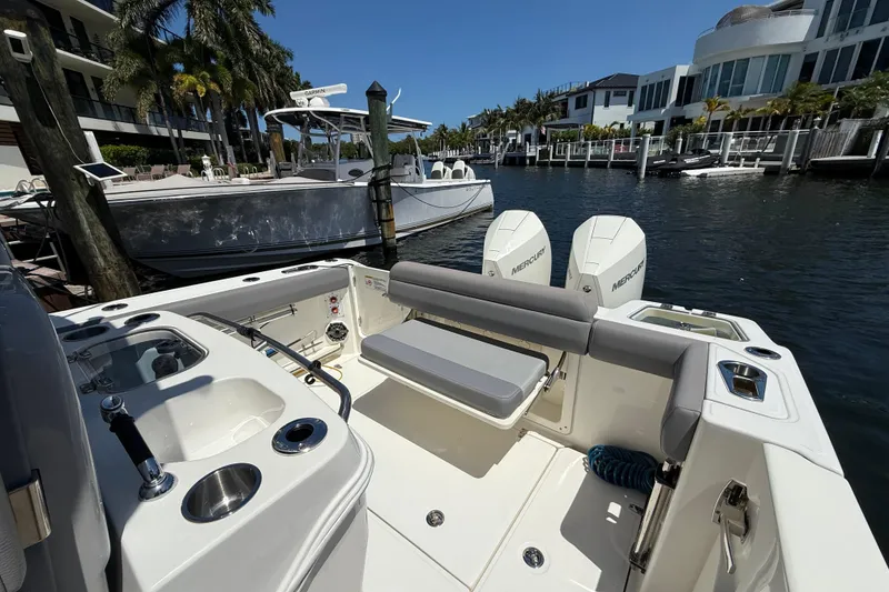 Slide: The Image of 2024 Boston Whaler 280 Outrage boat docked, featuring dual Mercury engines and sleek seating. - 20