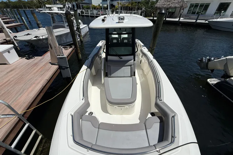 Slide: The Image of 2024 Boston Whaler 280 Outrage docked, showcasing spacious seating and sleek design. - 23