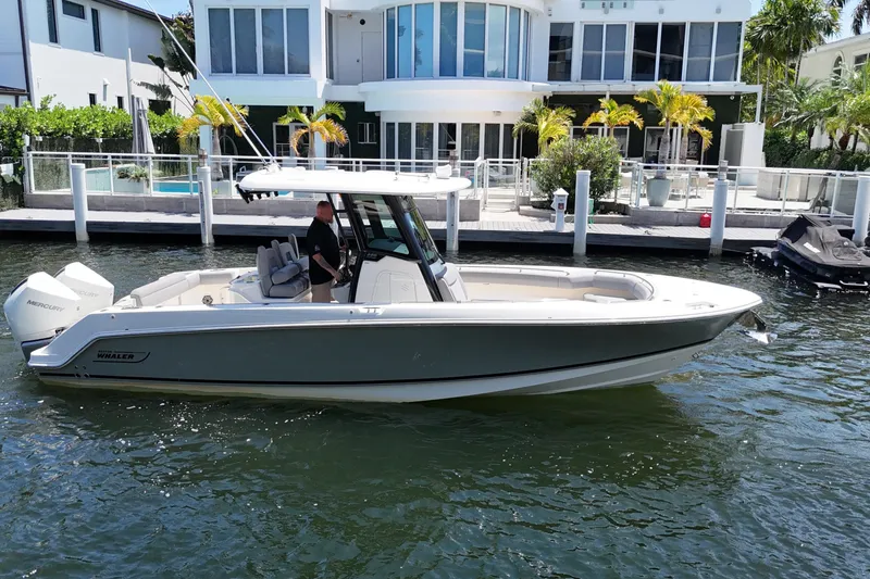 Slide: The Image of 2024 Boston Whaler 280 Outrage boat docked near modern waterfront home. - 4