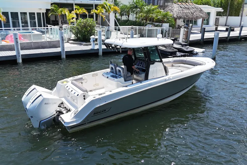 Slide: The Image of 2024 Boston Whaler 280 Outrage boat docked, featuring sleek design and powerful engines. - 7