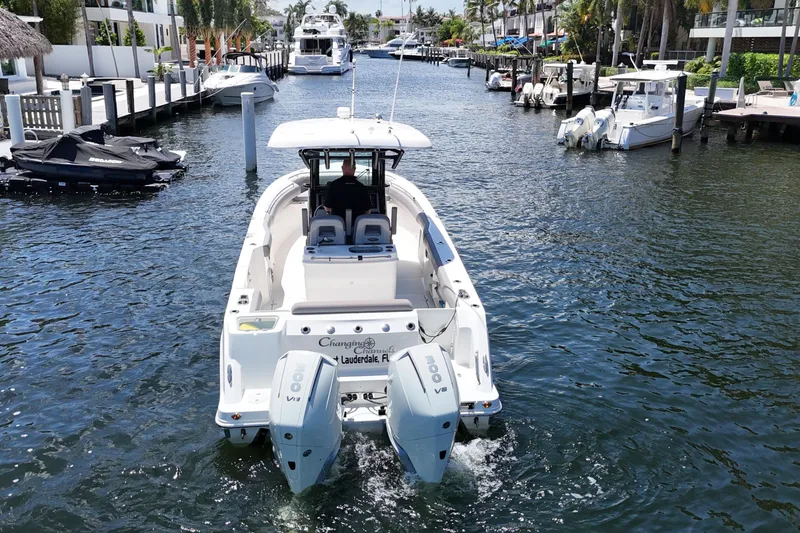 Slide: The Image of 2024 Boston Whaler 280 Outrage cruising in a scenic canal with twin engines. - 8