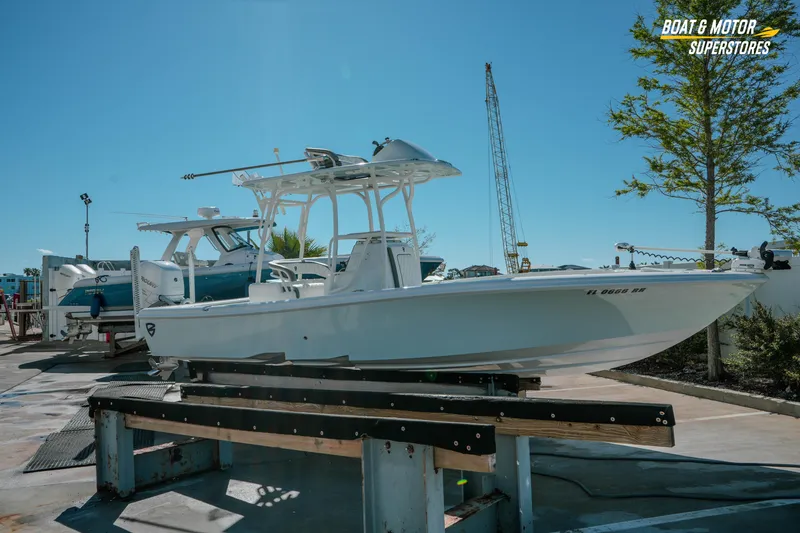 Slide: The Image of 2018 Barker Boatworks 26 Open on display at a boat dealership under clear blue skies. - 7