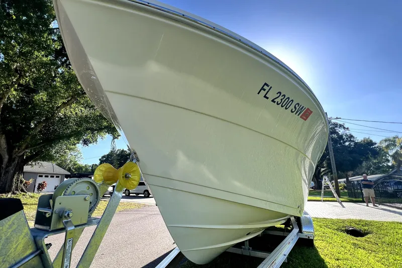 Slide: The Image of 2021 Cobia 240 Center Console boat on trailer, sunny day, residential area. - 10