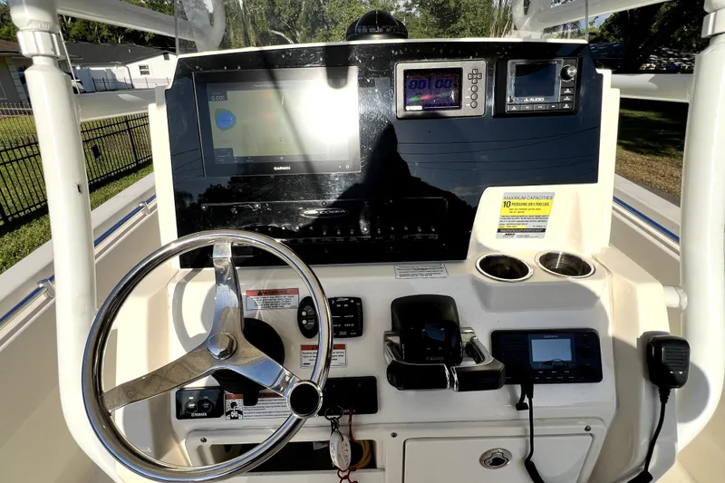 Slide: The Image of 2021 Cobia 240 Center Console dashboard with steering wheel and navigation equipment. - 100