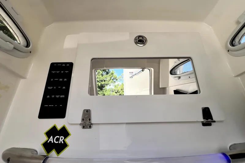 Slide: The Image of Interior view of a 2021 Cobia 240 Center Console boat with control panel and window. - 104