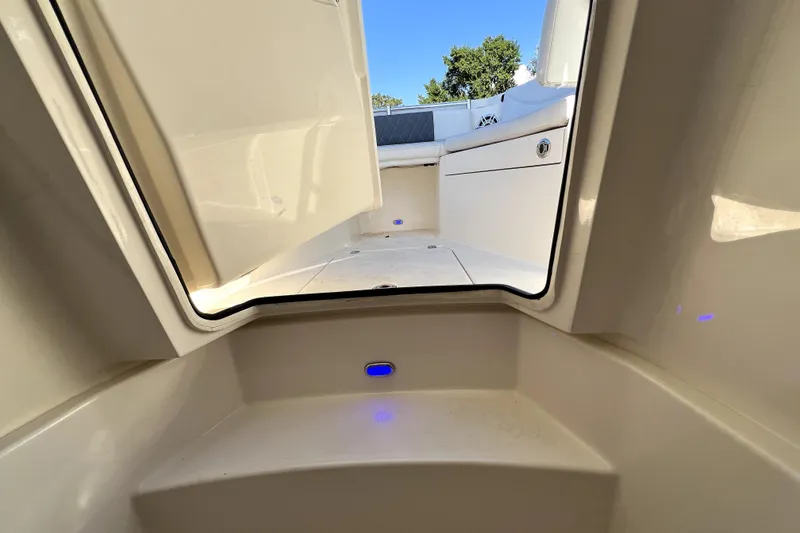 Slide: The Image of 2021 Cobia 240 Center Console boat interior with open hatch and seating area. - 106