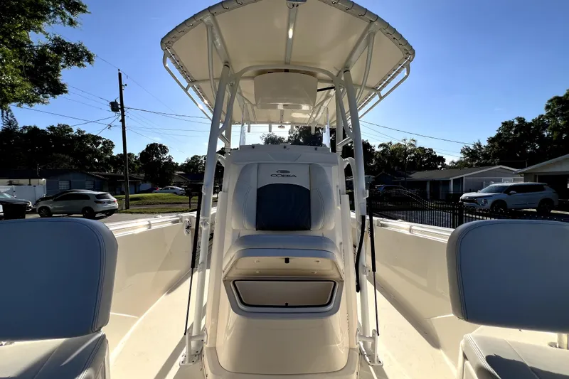 Slide: The Image of 2021 Cobia 240 Center Console boat with T-top and seating, parked outdoors. - 112