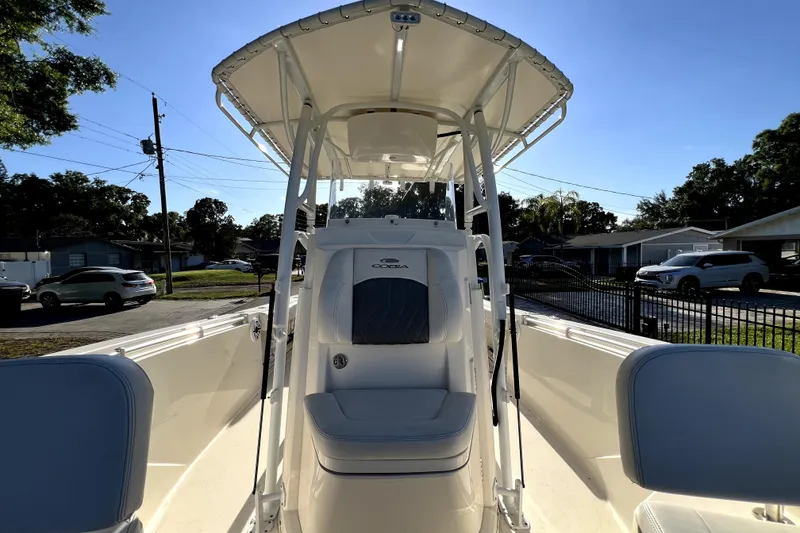 Slide: The Image of 2021 Cobia 240 Center Console boat with T-top, parked in a residential area. - 113
