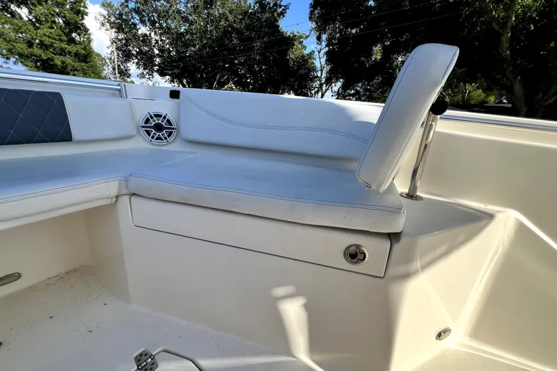 Slide: The Image of 2021 Cobia 240 Center Console boat seating area with cushioned bench and speaker. - 126