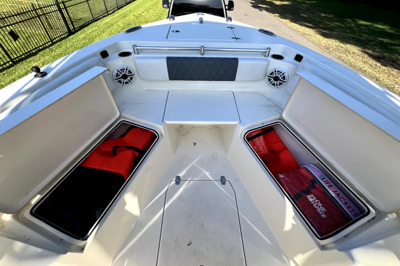 Slide: The Image of 2021 Cobia 240 Center Console boat with open storage compartments and life jackets. - 132