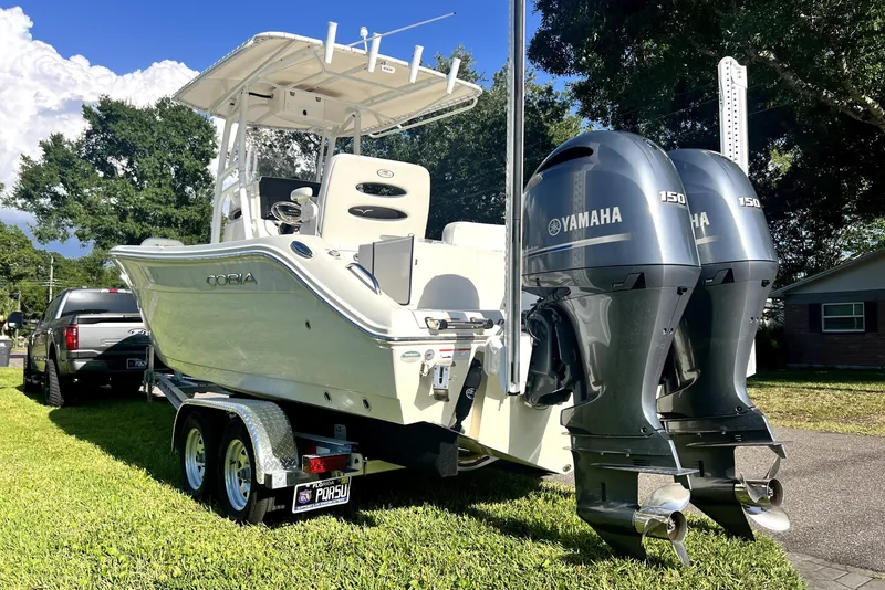 Slide: The Image of 2021 Cobia 240 Center Console boat with dual Yamaha engines on a trailer. - 14