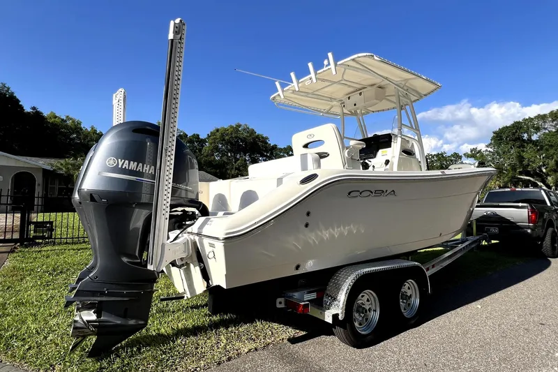 Slide: The Image of 2021 Cobia 240 Center Console boat on trailer with Yamaha engine, parked outdoors. - 16