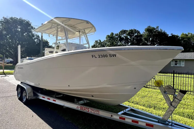 Slide: The Image of 2021 Cobia 240 Center Console boat on trailer in sunny residential area. - 19