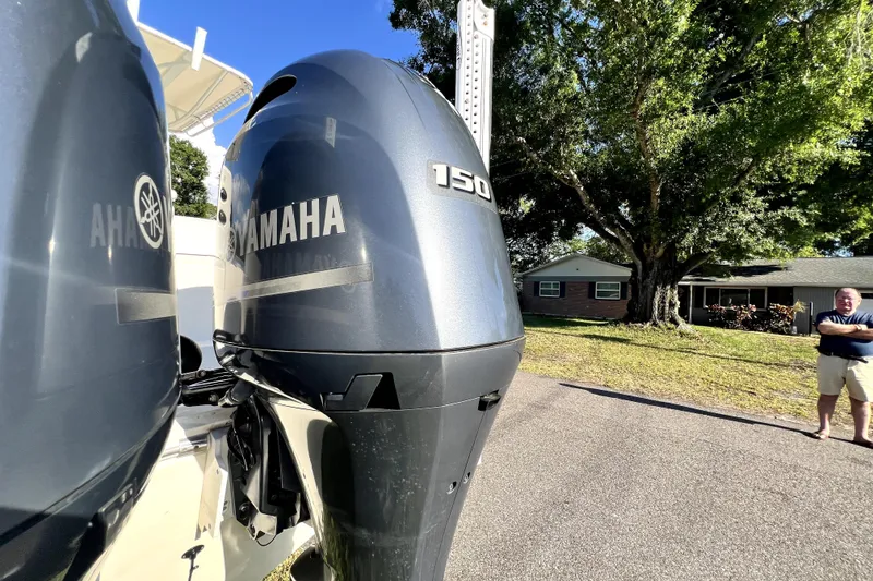 Slide: The Image of Yamaha 150 outboard engines on a 2021 Cobia 240 Center Console boat, parked outdoors. - 25