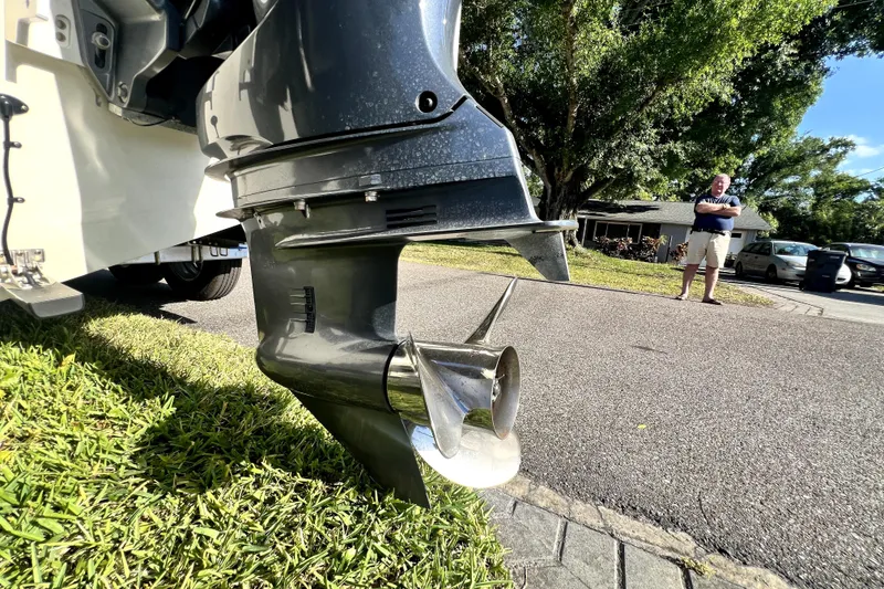 Slide: The Image of Outboard motor of 2021 Cobia 240 Center Console on grass, person in background. - 27