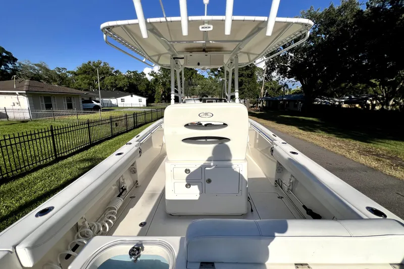 Slide: The Image of 2021 Cobia 240 Center Console boat with spacious deck and seating, parked outdoors. - 29