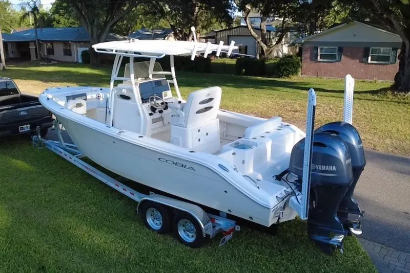 Slide: The Image of 2021 Cobia 240 Center Console boat on trailer, parked in residential area. - 3