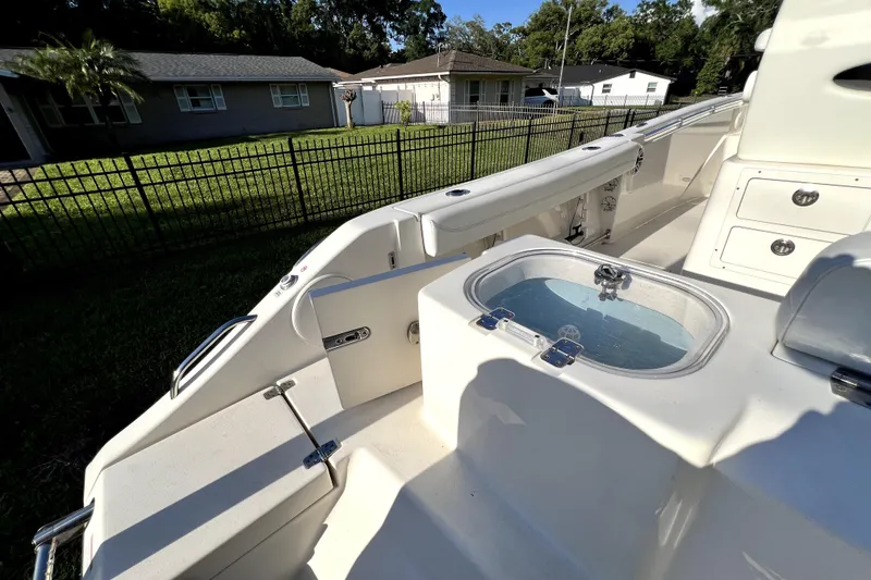 Slide: The Image of 2021 Cobia 240 Center Console boat with livewell, docked near residential area. - 32